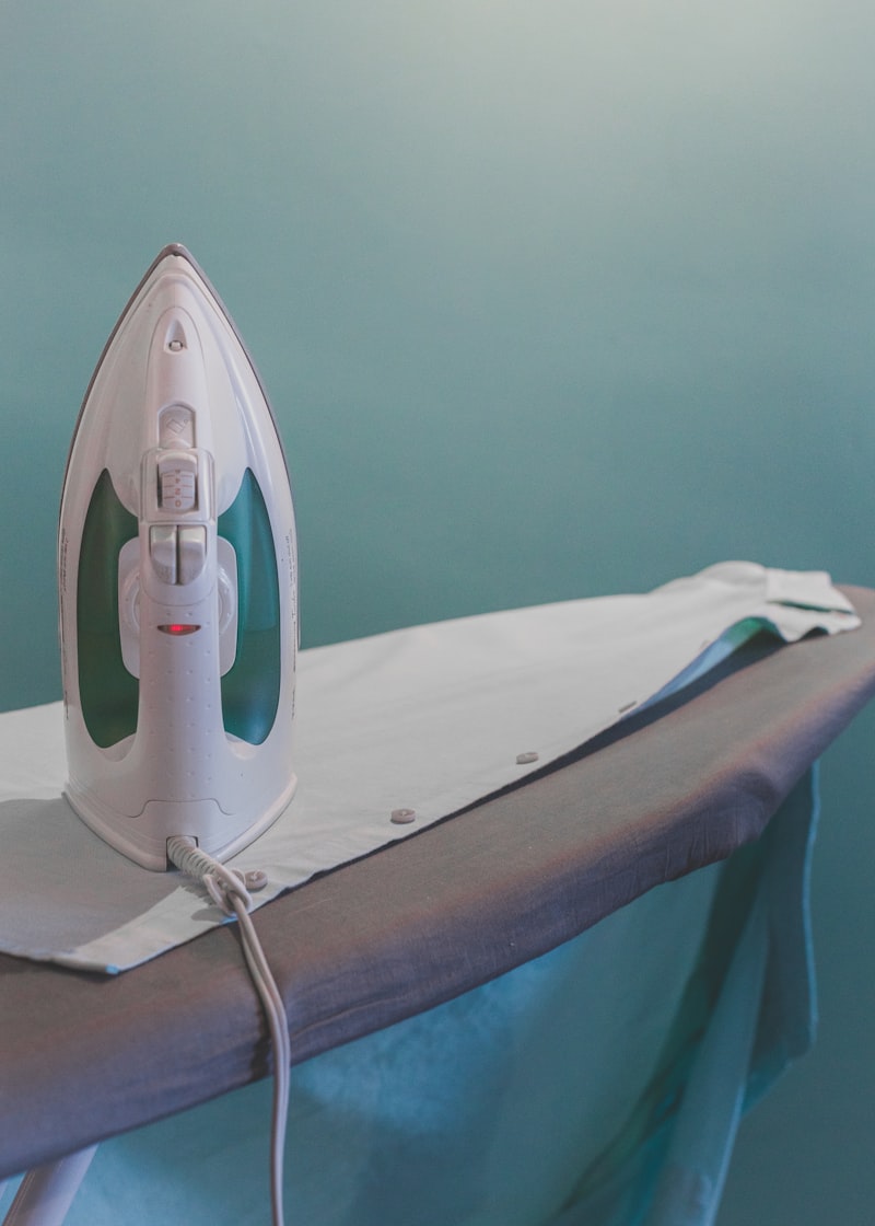 A steam iron standing on an ironing board